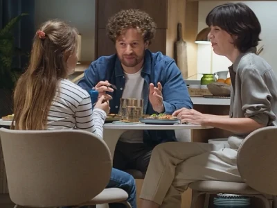 Ein Mädchen mit dunklen Locken hustet in die Armbeuge.