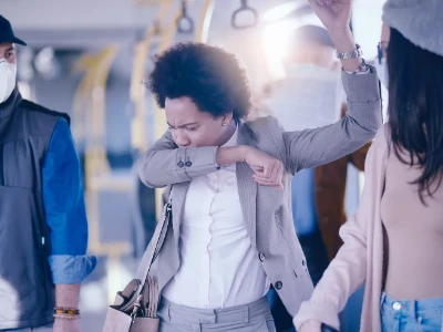 Kobieta kaszle w łokieć jadąc do pracy autobusem