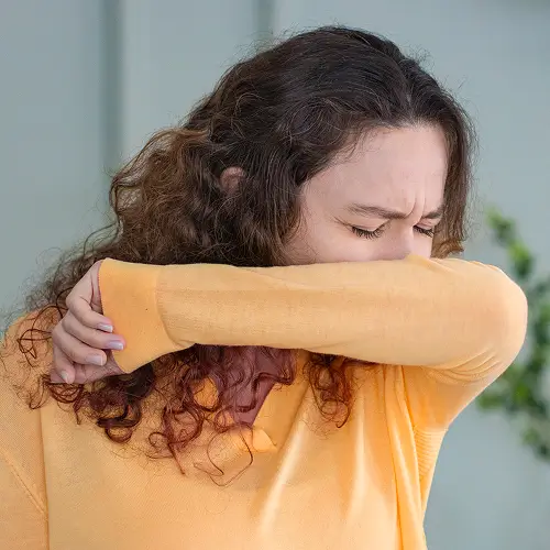 Eine Frau verabreicht ihrer kleinen Tochter Hustensaft mit einem Löffel.
