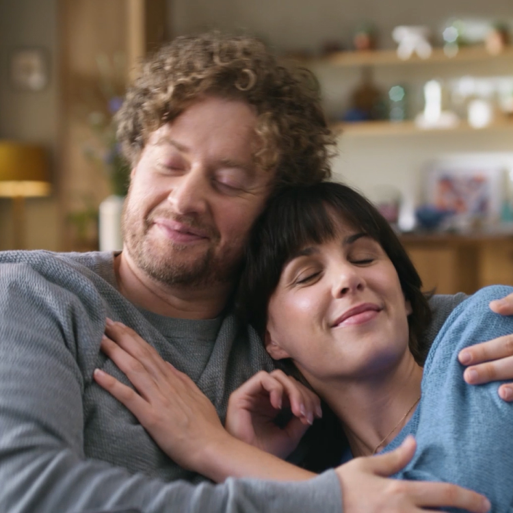 Przeziębiona rodzina siedząca w łóżku i dmuchająca nosy w chusteczki