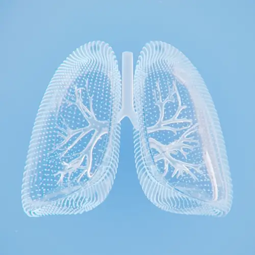 Kobieta siedząca na oknie pijąc herbatę, patrząc przez okno na ośnieżone dachy