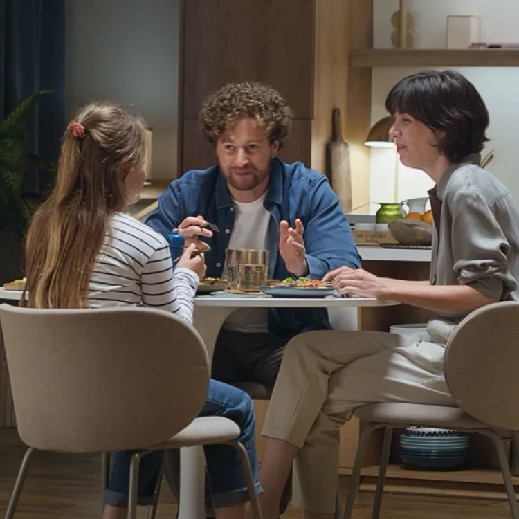 Ein Mädchen mit dunklen Locken hustet in die Armbeuge.